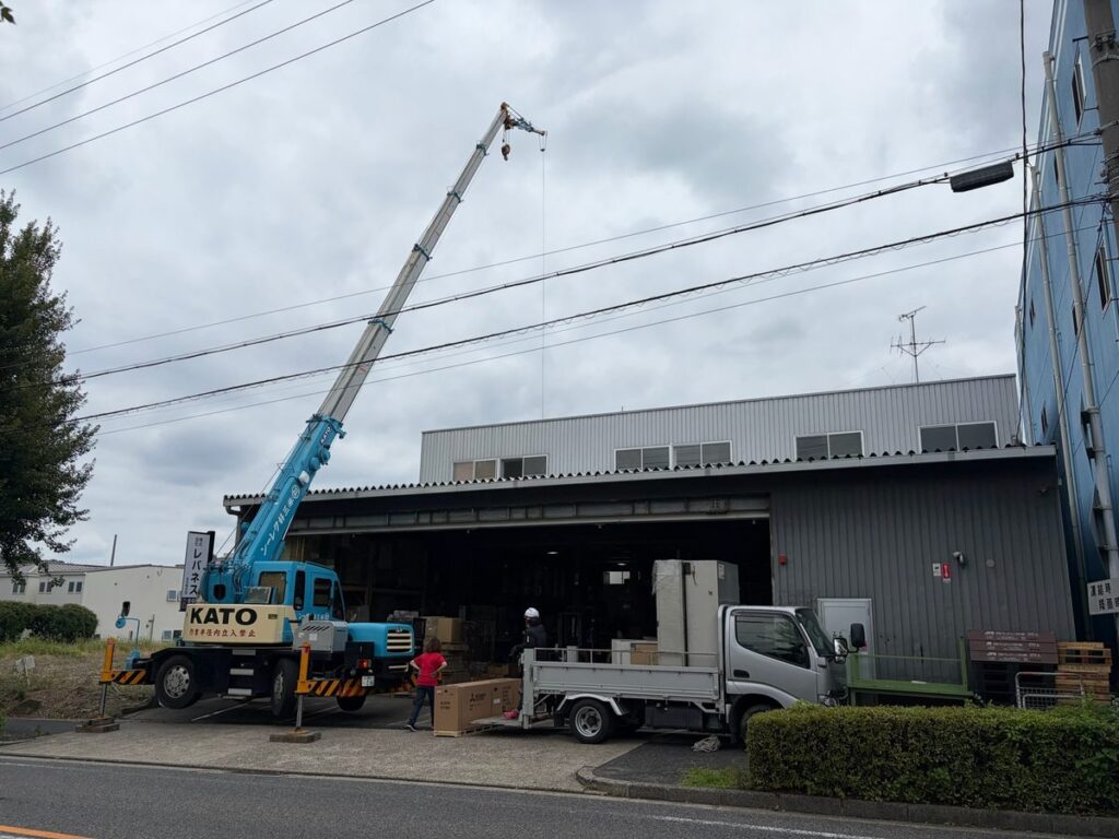 クレーン車で業務用エアコンを搬入する工事（道路使用の調整あり）