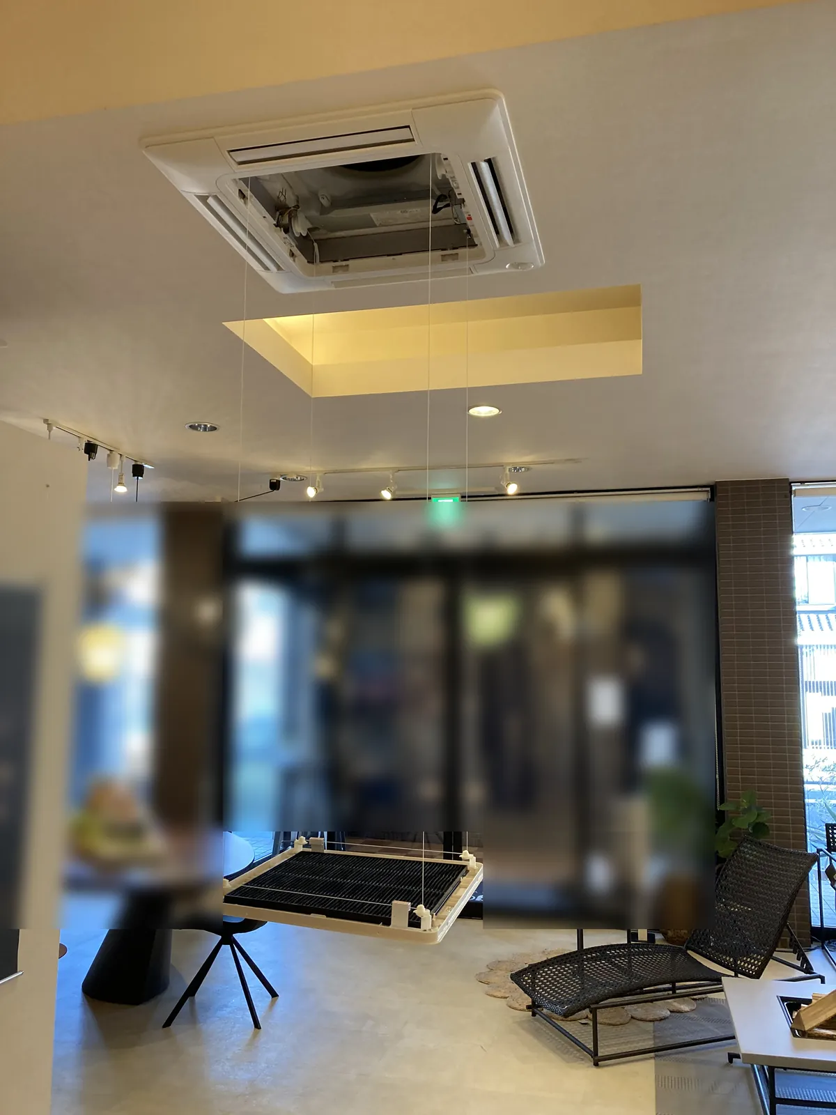 名古屋市の物販店で、自動昇降パネルの吸込グリルがワイヤーで床の近くまで降りてきた天井カセット形の業務用エアコン