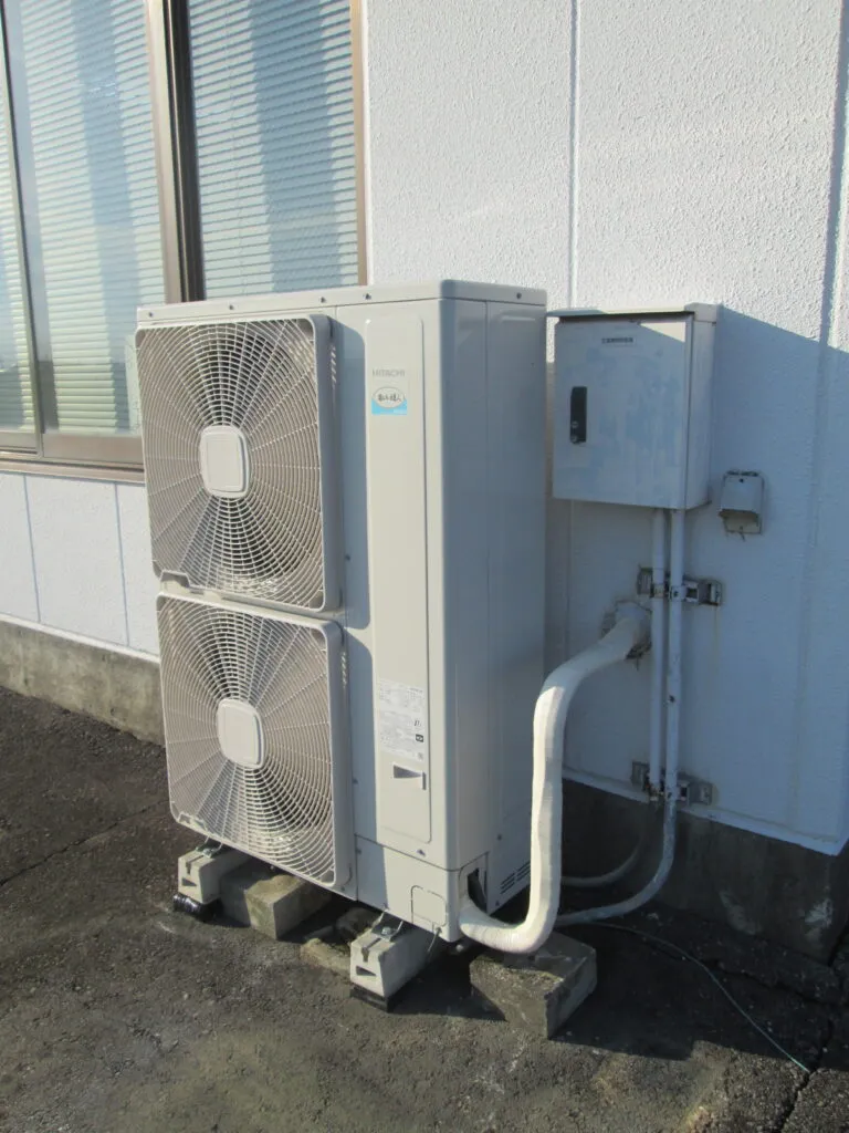 事務所の外壁沿いに設置された業務用エアコンの室外機