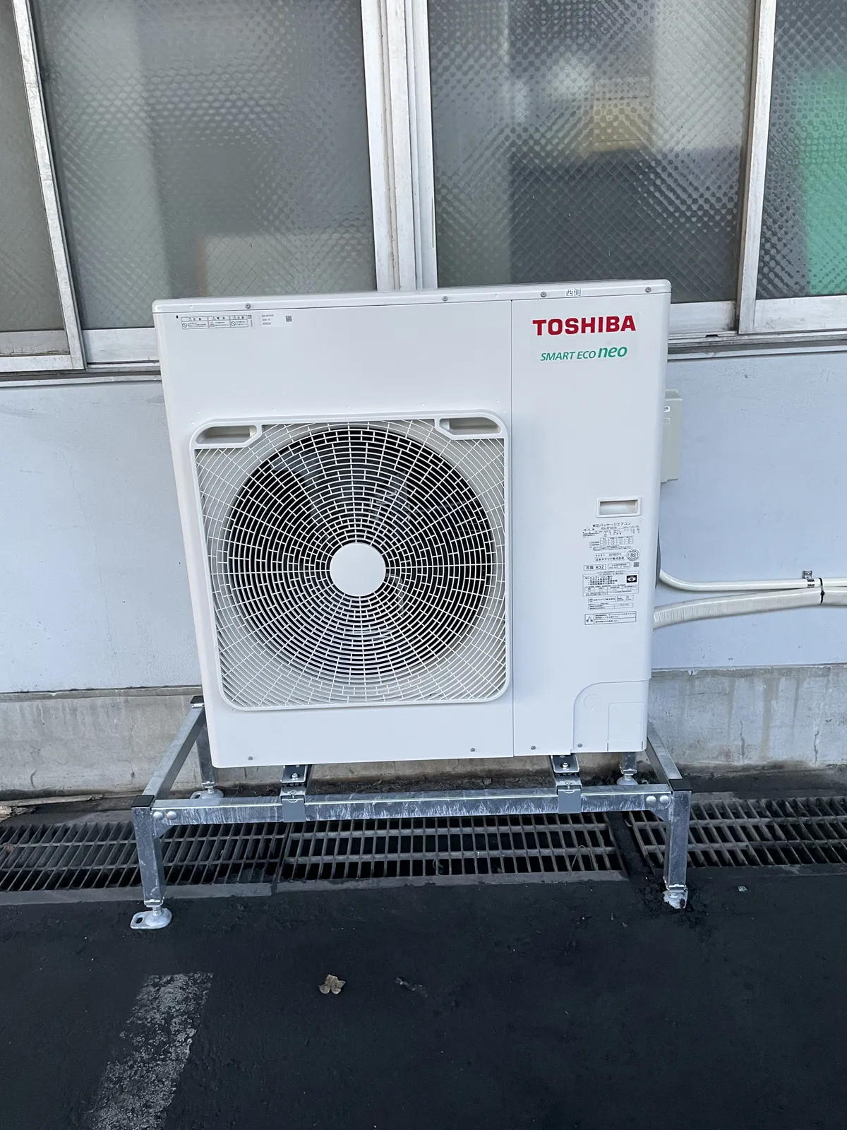 建物の外壁沿いの架台に設置した業務用エアコンの室外機