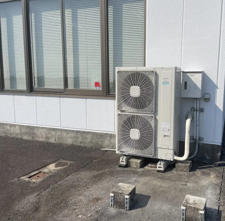 事務所の外壁沿いに設置された業務用エアコンの室外機