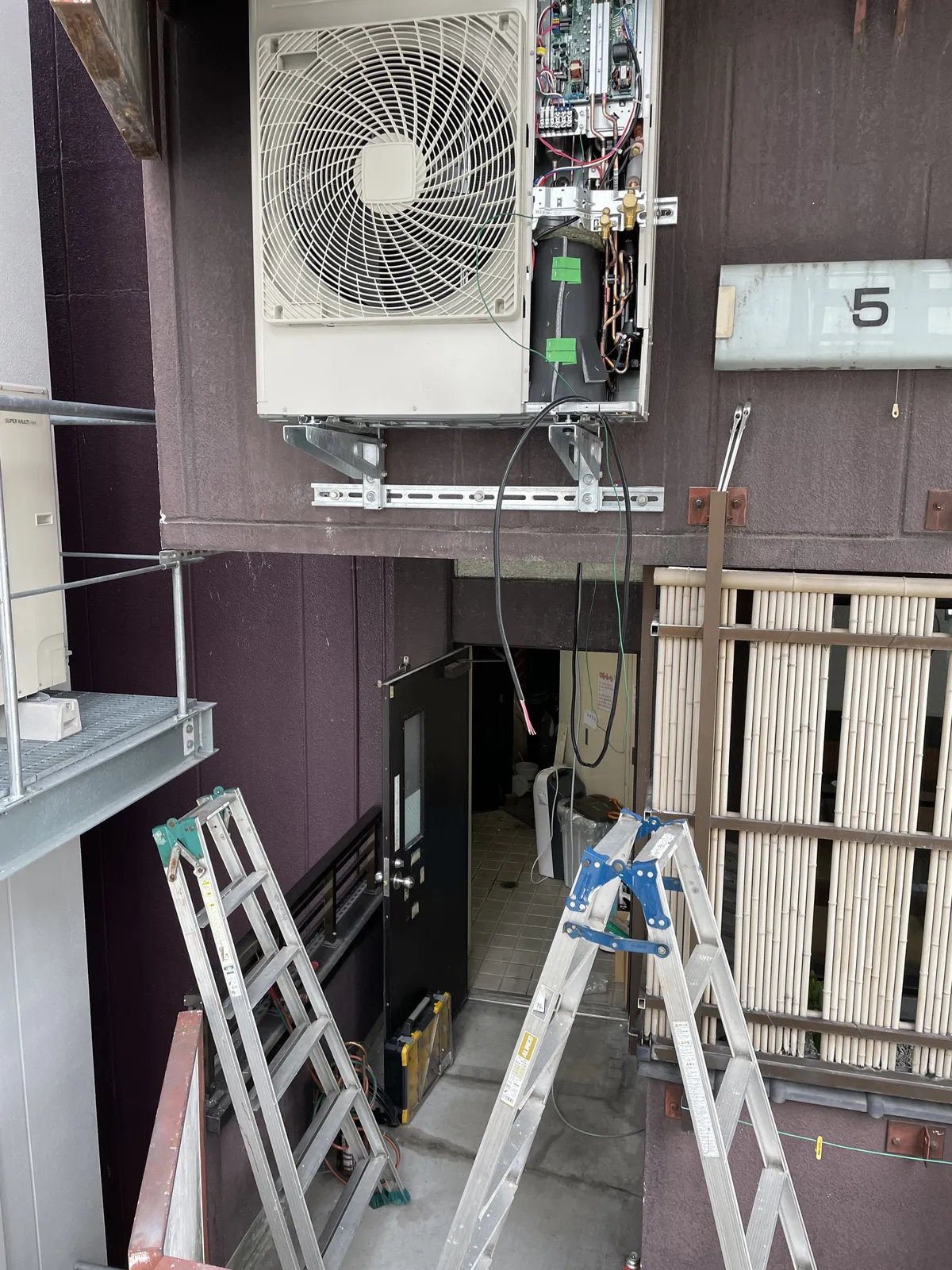 建物の外壁に金具で固定した業務用エアコンの室外機