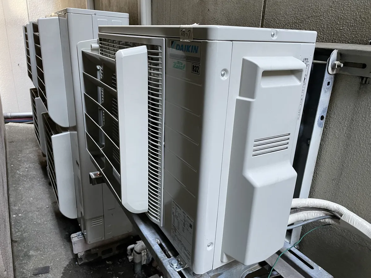 壁面の架台に並べて固定した業務用エアコンの室外機