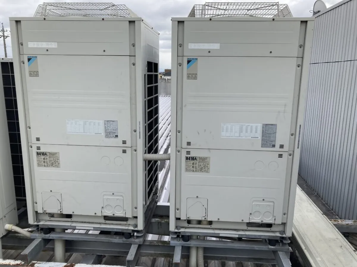 屋上の架台に並んで設置された業務用エアコンの室外機2台